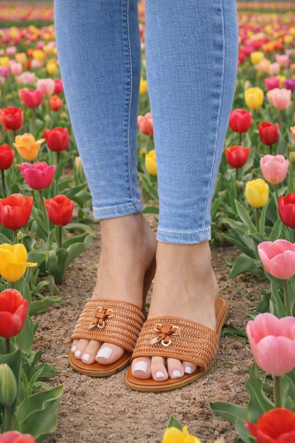 Person wearing brown sandals with floral background